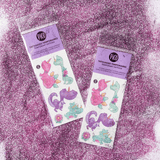 Tatouages dinosaures rose, violet et vert avec cornes de Pico Tatoo sur décor paillettes