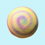 Scoop Bombe de bain moussante de savonnerie bon bain. Fragrance satsuma (agrumes et musc blanc). Couleur jaune avec spirale violette et verte.
